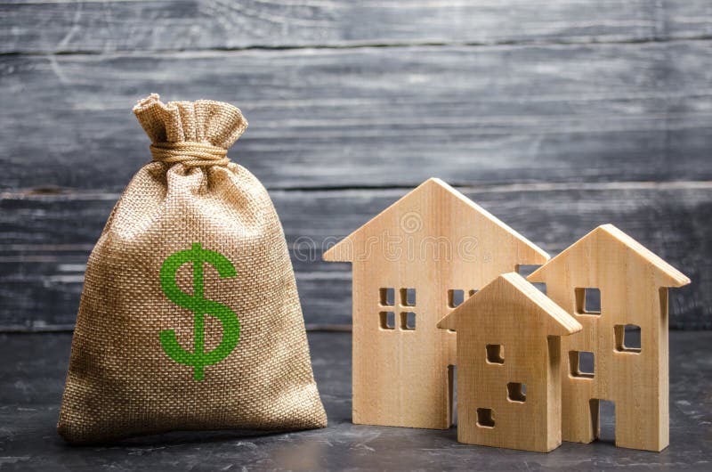 A bag with money and three houses. Concept of real estate acquisition and investment. Affordable cheap loan, mortgage. Taxes royalty free stock images